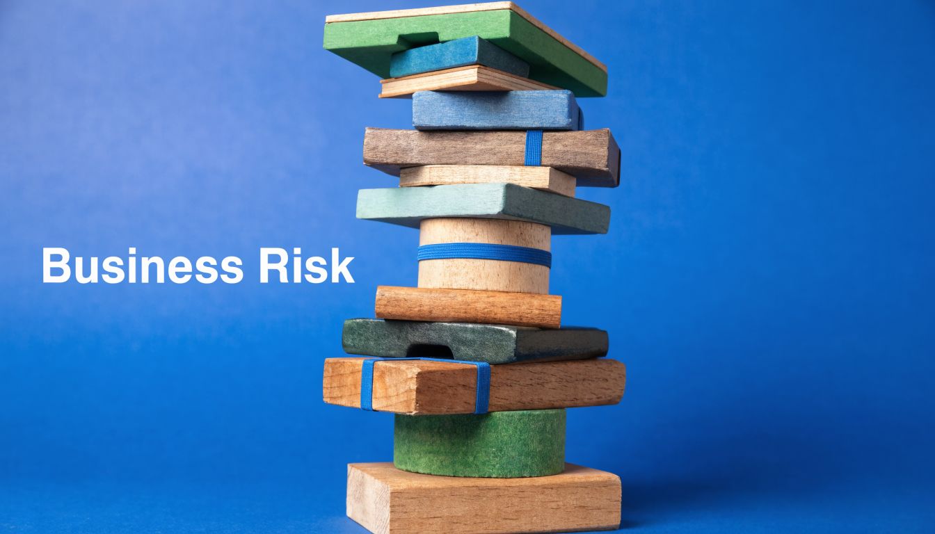 A stack of wooden blocks against a blue background representing the concept of business risk.