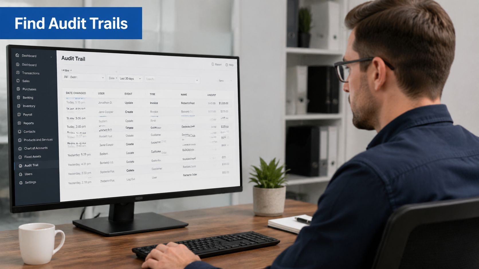 A professional man sitting at his desk working on a computer screen displaying audit trail records.